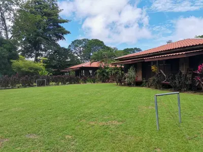 a yard in front of a building with a soccer field at Hotel Canto de Ballenas in Uvita