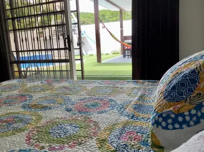 a quilt on top of a bed with a chair at VillaLore piscina exclusiva BBQ AC max 11 personas 5min playas in Carpintero