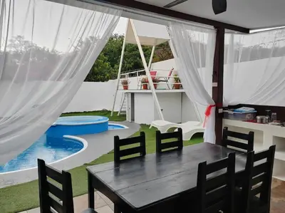 a dining room with a table and chairs and a pool at VillaLore piscina exclusiva BBQ AC max 11 personas 5min playas in Carpintero