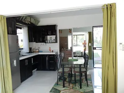 a kitchen with black cabinets and a table with chairs at Sweet Torres Estudio 2pers in Coco