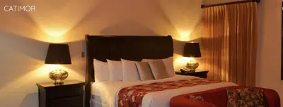a bedroom with a large bed with two lamps at Hotel Boutique Casona del Cafetal and Lakeside Restaurant in Cachí