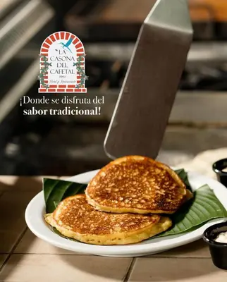 two pancakes on a white plate with a knife at Hotel Boutique Casona del Cafetal and Lakeside Restaurant in Cachí