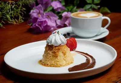 a piece of cake with a strawberry and a cup of coffee at Hotel Boutique Casona del Cafetal and Lakeside Restaurant in Cachí