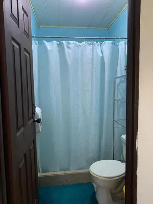 a bathroom with a toilet and a shower curtain at Alicama in Puerto Limón