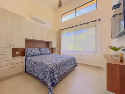 a bedroom with a bed and a large window at Coco Luna House 2 bed 3 bath in Coco