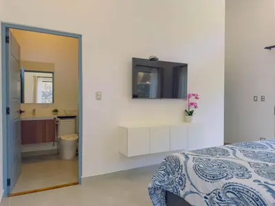 a bedroom with a bed and a sink and a mirror at Coco Luna House 2 bed 3 bath in Coco