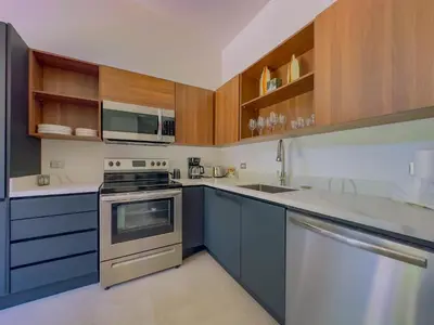a kitchen with blue cabinets and a stove top oven at Coco Luna House 2 bed 3 bath in Coco