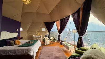 a bedroom with a tent with a large window at FERNANDA Dome at FéLIZA Rainforest Domes in Monteverde Costa Rica