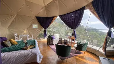 a living room with a bed and a large window at FERNANDA Dome at FéLIZA Rainforest Domes in Monteverde Costa Rica