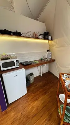 a kitchen in a tent with a table and a microwave at FERNANDA Dome at FéLIZA Rainforest Domes in Monteverde Costa Rica