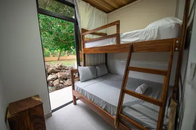 a room with two bunk beds and a window at SeaSurf House in Esterillos
