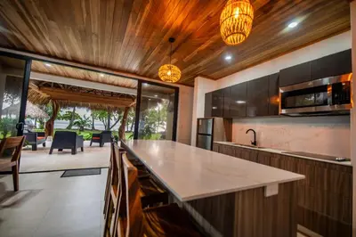 an open kitchen with a large island in a house at SeaSurf House in Esterillos