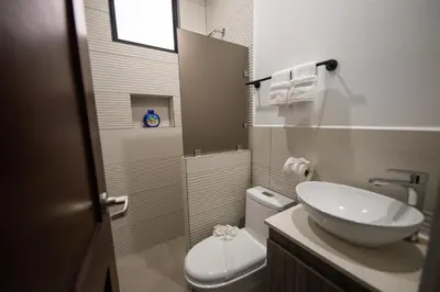 a bathroom with a sink and a toilet and a mirror at SeaSurf House in Esterillos