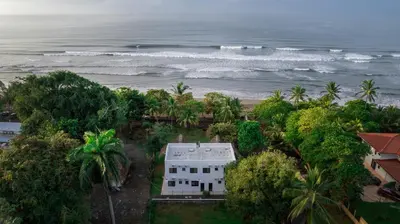 an aerial view of a house and the ocean at SeaSurf House in Esterillos