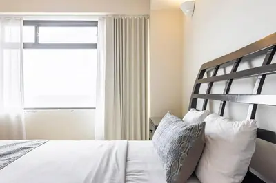 a bedroom with a bed with white sheets and a window at 3 Bedroom Condo in Croc's Casino Resort in Jacó