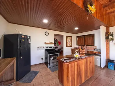 a kitchen with a black refrigerator and a counter at Campo Verde B&B - Monteverde Costa Rica in Monteverde Costa Rica