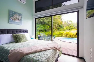 a bedroom with a bed and a sliding glass door at Casa para Vacacionar Increible en Bejuco in Loma