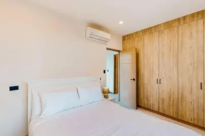 a bedroom with a white bed and wooden cabinets at Playa Conchal and Minas' Hidden Gem in Puerto Viejo