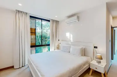 a white bedroom with a large bed and a window at Playa Conchal and Minas' Hidden Gem in Puerto Viejo
