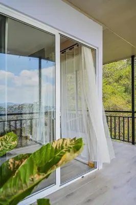 a room with a large window with a plant at Nosara Hideaway 1 - Mountain View Cabins & BREAKFAST PROVIDED in Naranjal