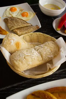 a basket of bread and eggs on a table at Nosara Hideaway 1 - Mountain View Cabins & BREAKFAST PROVIDED in Naranjal