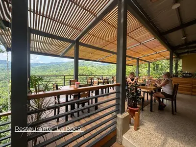 two women sitting at tables in a restaurant with a view at Nosara Hideaway 1 - Mountain View Cabins & BREAKFAST PROVIDED in Naranjal