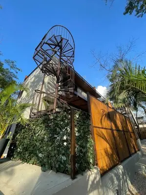 a building with a staircase on the side of it at Green Turtle Townhome #2 Private Pool & Garden 300 Mtrs to Beach in Tamarindo