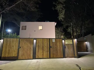 a house behind a wooden fence at night at Green Turtle Townhome #2 Private Pool & Garden 300 Mtrs to Beach in Tamarindo