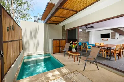 an indoor swimming pool in a house with a table and chairs at Green Turtle Townhome #3 Private Pool & Garden 300 Mt to Beach in Tamarindo