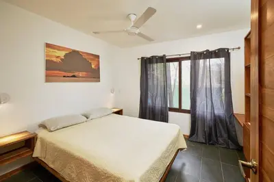 a bedroom with a bed and a window at Green Turtle Townhome #3 Private Pool & Garden 300 Mt to Beach in Tamarindo