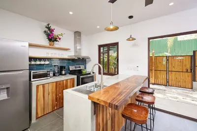 a kitchen with a wooden counter top and a refrigerator at Green Turtle Townhome #3 Private Pool & Garden 300 Mt to Beach in Tamarindo