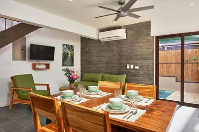 a dining room with a wooden table and chairs at Green Turtle Townhome #4 Private Pool & Garden 300Mtrs to Beach in Tamarindo