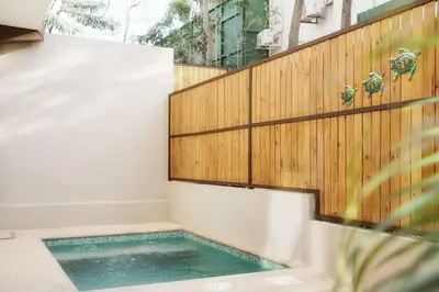 a swimming pool in a bathroom with a wooden wall at Green Turtle Townhome #4 Private Pool & Garden 300Mtrs to Beach in Tamarindo
