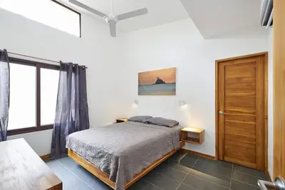 a bedroom with a bed and a window at Green Turtle Townhome #4 Private Pool & Garden 300Mtrs to Beach in Tamarindo