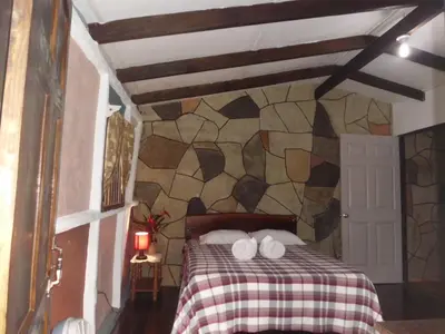 a bedroom with a bed with two towels on it at Nacientes Lodge in Bijagua