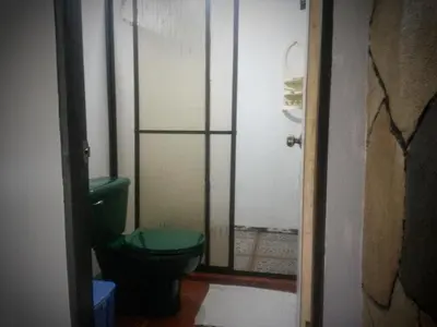 a bathroom with a green toilet and a glass door at Nacientes Lodge in Bijagua