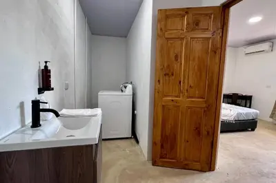 a bathroom with a sink and a wooden door at Zen Studio in Jacó