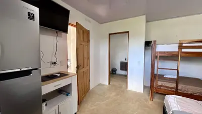a small room with a kitchen and a bunk bed at Zen Studio in Jacó