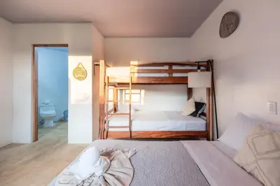 a bedroom with two bunk beds and a bathroom at Zen Studio in Jacó