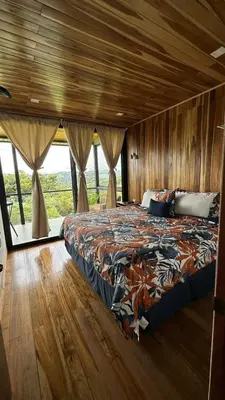 a bedroom with a bed in a room with wooden walls at Casa horizonte Verde in Sierra