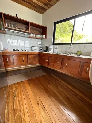 a kitchen with wooden cabinets and a large window at Casa horizonte Verde in Sierra