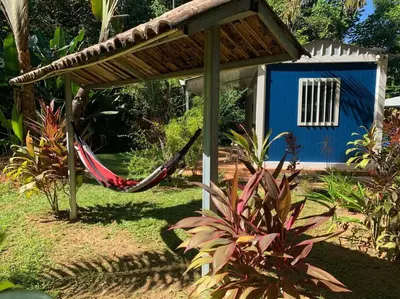 a hammock in front of a blue house at Ojochal maison moderne piscine creusée in Ojochal