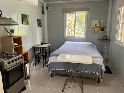 a small bedroom with a bed and a stove at Ojochal maison moderne piscine creusée in Ojochal