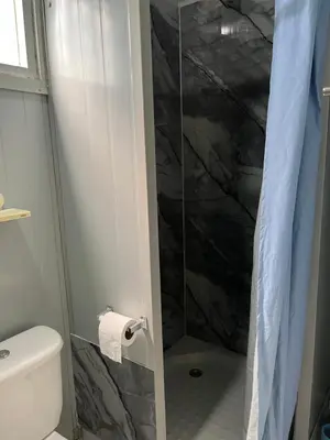 a bathroom with a glass shower with a toilet at Ojochal maison moderne piscine creusée in Ojochal