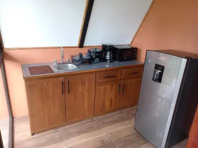 a kitchen with a sink and a refrigerator at Small Country House in Monterrey