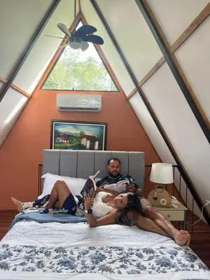 a man and two girls laying on a bed in a attic at Small Country House in Monterrey