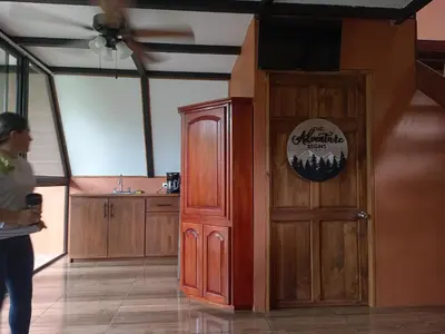 a woman standing next to a wooden door with a sign on it at Small Country House in Monterrey