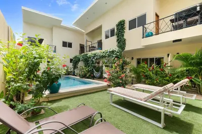 a backyard with a swimming pool and a house at Pierre and Colors TAMARINDO in Tamarindo