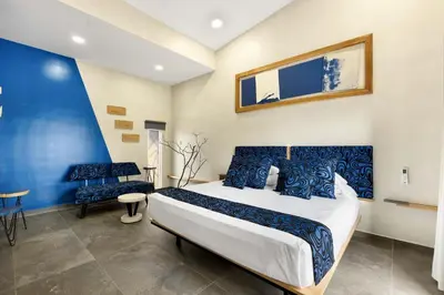 a bedroom with a large bed and a blue wall at Pierre and Colors TAMARINDO in Tamarindo