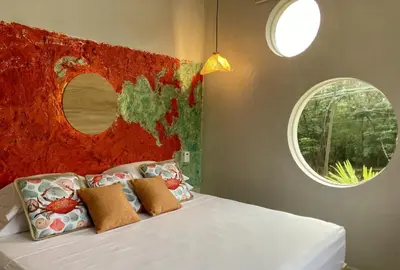 a bedroom with a white bed with two windows at Pierre and Colors TAMARINDO in Tamarindo